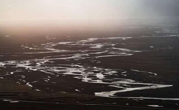 Glacial river full of meanders reaching the shore — Stockfoto