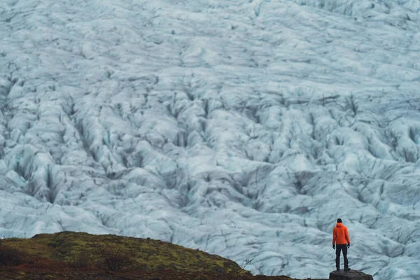 Unrecognizable tourist rear view looking to a massive glacier — стоковое фото