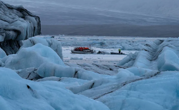 Icebergs maciços na lagoa Jokulsarlon na Islândia com barco turístico — Fotografia de Stock