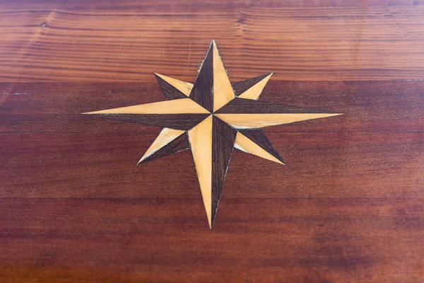 Kompas Wzniósł Się Nad Drewnianym Stołem — Zdjęcie stockowe