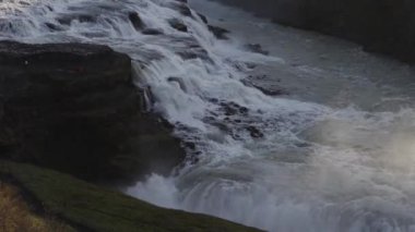 Gullfoss Şelalesi, İzlanda 'da kayalıklarda yürüyen turistlerle dolu.