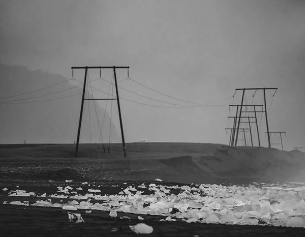 Ijsbergen Het Donkere Zwarte Zandstrand Met Elektriciteitsleidingen Mistige Sfeer — Stockfoto