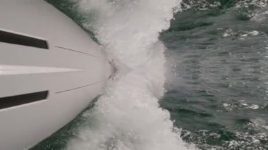 Sailboat abstract reflection sailing with huge waves breaking in slow-mo