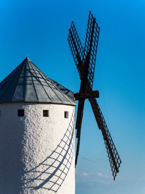 Güneşin batışında mavi gökyüzü ve bıçaklarla izole edilmiş muhteşem eski yel değirmeni