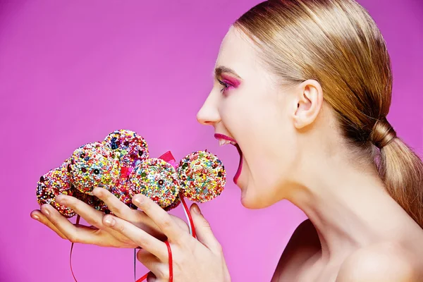 Piękne dziewczyny jedzenie cukierków kulki — Zdjęcie stockowe