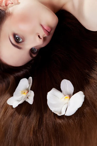 Menina com orquídeas no cabelo — Fotografia de Stock