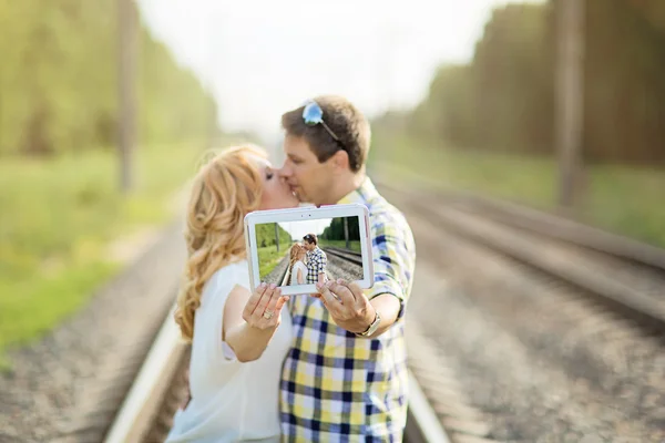 Couple kissing and holding their picture — Stock Photo, Image