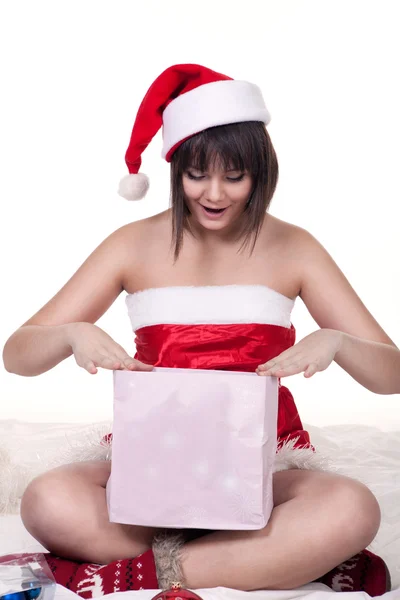 Girl in christmas hat opening present — Stock Photo, Image