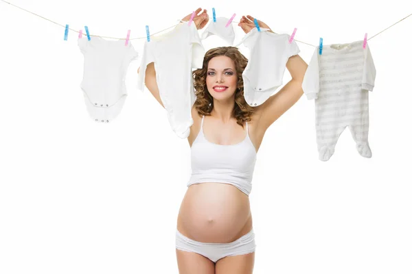 Pregnant woman with kids clothes — Stock Photo, Image