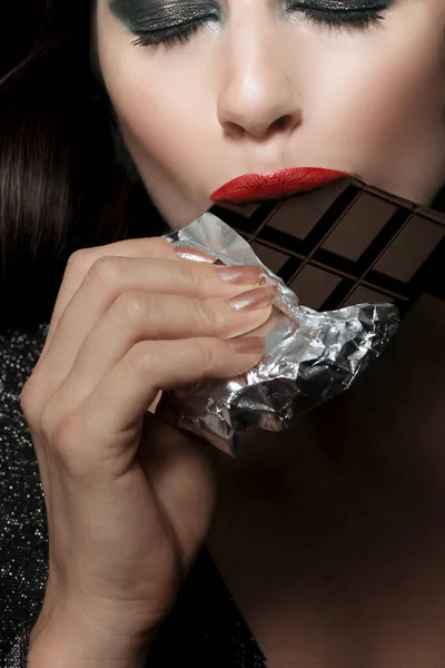 Gyönyörű Fiatal Barna Lány Egy Sötét Háttér Eszik Csokoládét — Stock Fotó