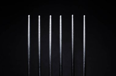 Siyah arka planda paslanmaz çelik çubuklar.