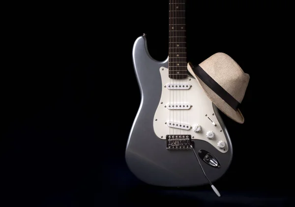 黒の背景に隔離された帽子と銀の電気ギター — ストック写真