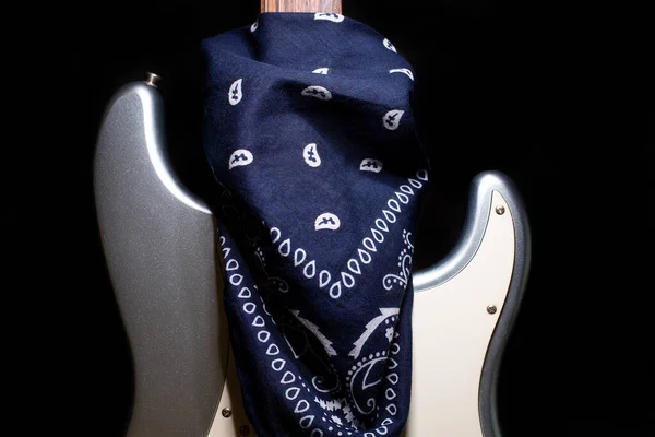 Silver electric guitar with blue bandana isolated on black background. — Stock Photo, Image