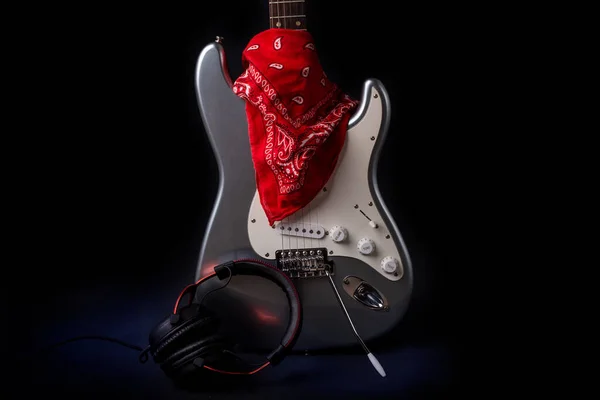 Stříbrná elektrická kytara s červeným šátkem izolované na černém pozadí — Stock fotografie
