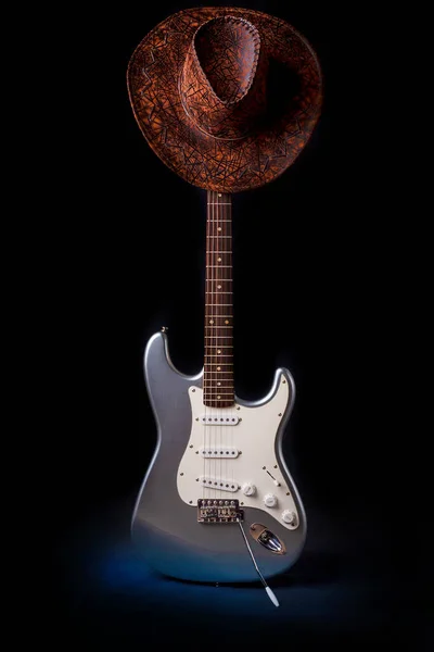 Silver electric guitar with hat isolated on black background — Stock Photo, Image