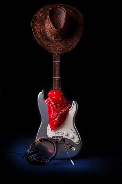 Srebrna gitara elektryczna z czerwonym bandana kapelusz i słuchawki — Zdjęcie stockowe