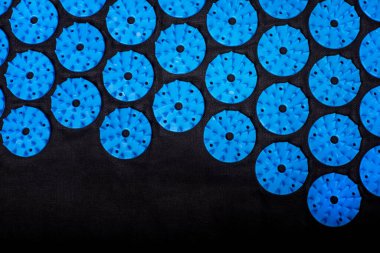 Akupunktur mavi paspası ve siyah arka planda birçok plastik çivi var. Alternatif terapi ve rahatlama ilacı.