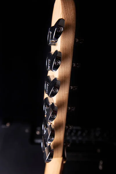 Bagian dari headstock gitar listrik terhadap latar belakang hitam. — Stok Foto