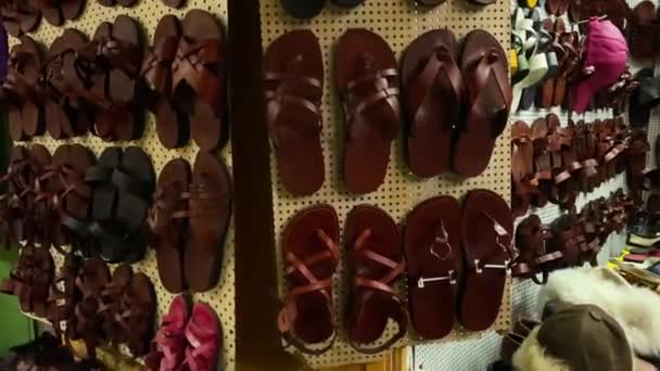 Tourists visit bazaar market street in Old City Jerusalem, buying sandals — Stock Video