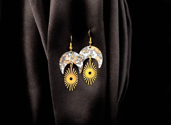 Metal Earrings Hanging Black Silk Background — Zdjęcie stockowe