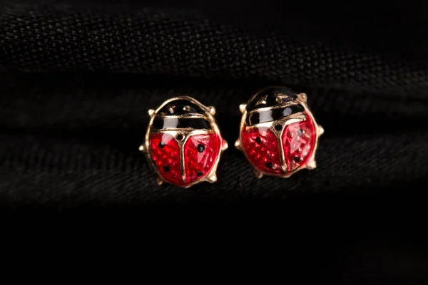 Ladybug Shaped Gold Stud Earrings Black Fabric Background — Zdjęcie stockowe