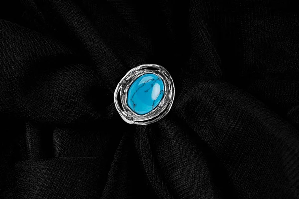 Silver ring med turkos sten på svart tyg bakgrund. — Stockfoto