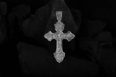 Kömür parçalarında gümüş haç gerdanlığı.