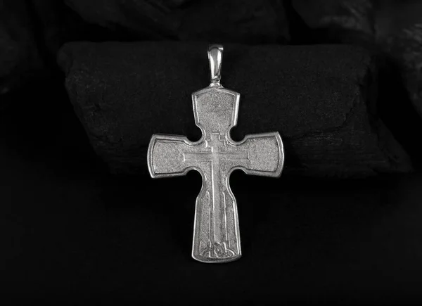 Collar crucifijo de plata cruz sobre trozos de carbón —  Fotos de Stock