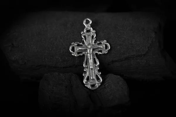 Collar crucifijo de plata cruz sobre trozos de carbón.. —  Fotos de Stock