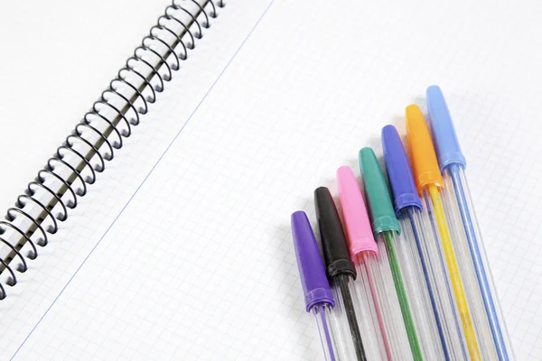 Gekleurde pennen op notebook — Stockfoto
