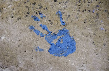 Detail of handprint painted on a wall, blue decoration