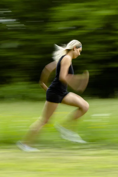 Mujer rubia corriendo en negro Imágenes de stock libres de derechos