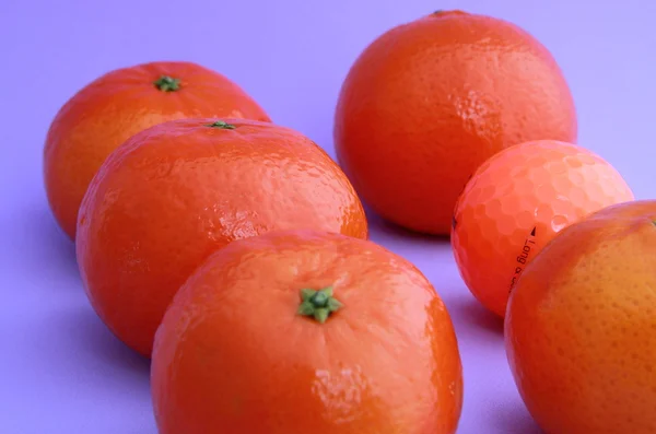 Golf ball and tangerines — Stock Photo, Image