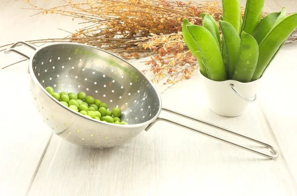Colander and natural peas — Stock Photo, Image