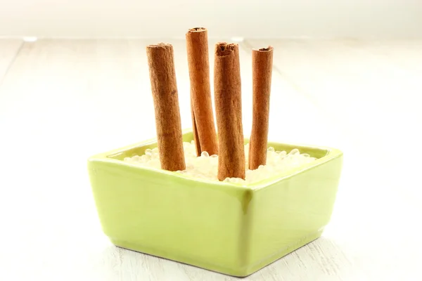 Cinnamon in green pot — Stock Photo, Image