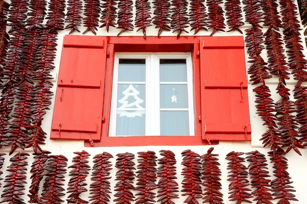 Espelette papryki wokół okna — Zdjęcie stockowe