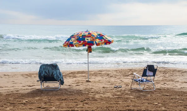 Parasol en stoelen op het strand — Stockfoto