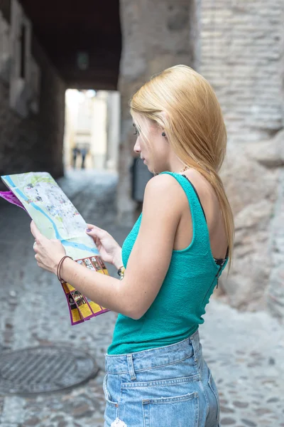 Jonge vrouwelijke toeristische bestuderen van een kaart — Stockfoto