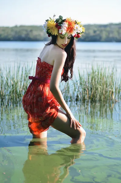 Portrait of Young beautiful woman wearing a wreath of wild flowers — Stock Photo, Image