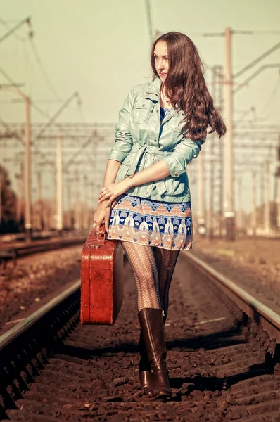 Young fashion girl with suitcase at railways — Stock Photo, Image