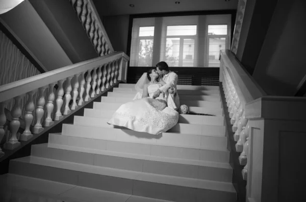 Frischvermählte sitzen auf der Treppe — Stockfoto