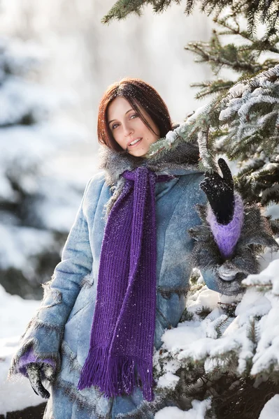 Hübsches Mädchen steht neben Tanne im Winterpark — Stockfoto