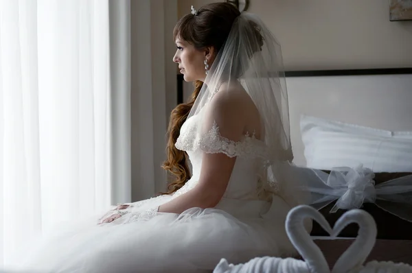 Krásná nevěsta, sedí na posteli — Stock fotografie