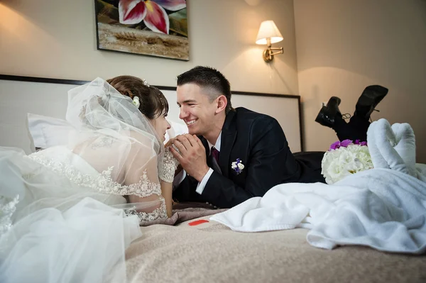 Newly married couple lie on the bed — Stock Photo, Image