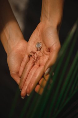 Değerli yuvarlak kolye narin kadın ellerinde.