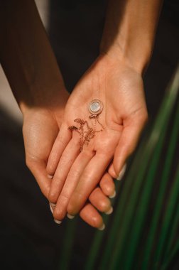 Değerli yuvarlak kolye narin kadın ellerinde.