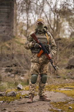 Soldier of the Armed Forces of Ukraine. Military man in tactical uniform with a machine gun in his hands