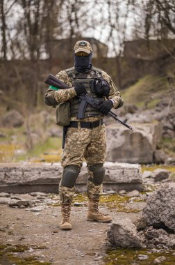 Soldier of the Armed Forces of Ukraine. Military man in tactical uniform with a machine gun in his hands