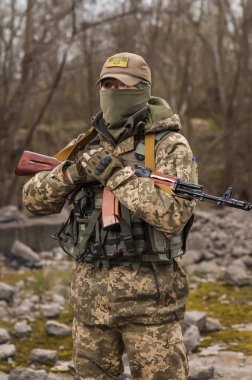 Soldier of the Armed Forces of Ukraine. Military man in tactical uniform with a machine gun in his hands