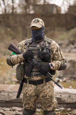 Soldier of the Armed Forces of Ukraine. Military man in tactical uniform with a machine gun in his hands